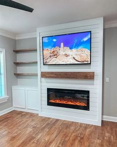 a flat screen tv mounted on the wall above a fireplace