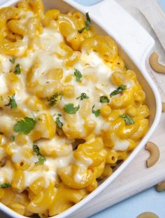 a bowl filled with macaroni and cheese on top of a blue tablecloth