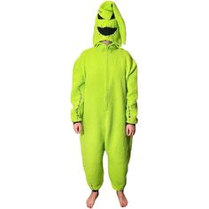 a person in a green monster costume standing on a white background with one foot up and the other leg down