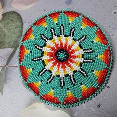 a colorful beaded brooch sitting on top of a table