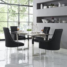 a glass table with black chairs and plates on it