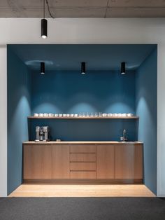 an empty room with blue walls and wooden counter top, along with black carpeting