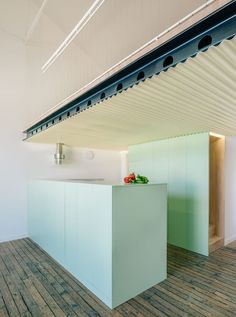 a kitchen with an island in the middle and wooden flooring on the other side