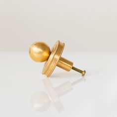 a pair of gold ear studs on a white surface