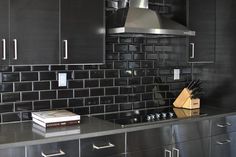 a kitchen with black cabinets and stainless steel appliances