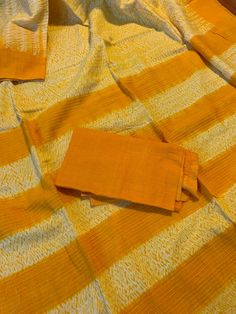 "A pure cotton saree using the \"Shibori\" (tie & dye) technique in a bright mustard yellow and white combination. Saree is completely handmade starting from weaving to dyeing. Condition: New Fabric: Pure 100% cotton Length: 5.5 metres Fall & Pico : Saree comes with fall and pico Blouse: Comes with running blouse piece. Customized stitching: available upon request with additional charges. Occasion: Casual, Wedding, Festivities, Party, Religious Note: We try to stay as accurate to the ori Yellow Handloom Cotton Silk Dupatta, Yellow Cotton Silk Handloom Dupatta, Festive Yellow Cotton Dupatta, Unstitched Yellow Block Print Saree, Unstitched Yellow Saree With Block Print, Unstitched Cotton Saree With Batik Print, Orange Unstitched Cotton Dupatta, Yellow Block Print Unstitched Saree, Unstitched Cotton Batik Print Saree