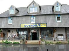 the outside of a building with a sign that says outhouse on it's front