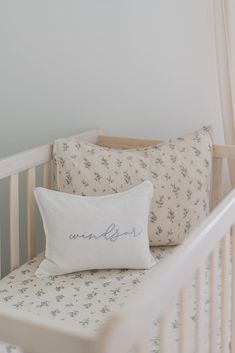 a white crib with two pillows on it