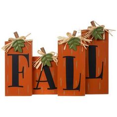 three wooden blocks with the word fall painted on them and two pumpkins tied to each other