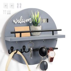 a wall mounted shelf with sunglasses, watch and key hooks on it that says welcome