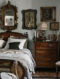 a bedroom with antique furniture and pictures on the wall