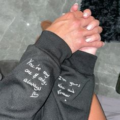 a person with their arm wrapped around each other and writing on the wristbands