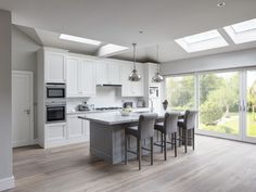 a large kitchen with white cabinets and an island