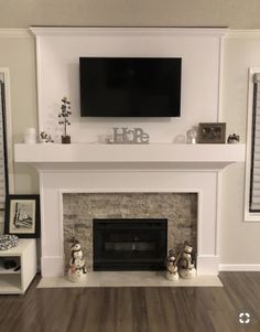 a living room with a fire place and television mounted above the mantel in front of it