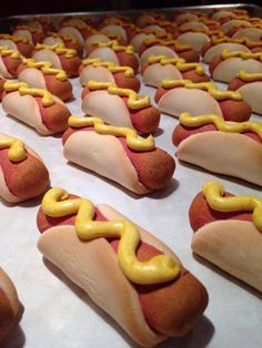 hotdogs with mustard on them are lined up