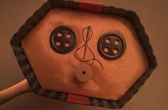 a doll made to look like a face with buttons on it