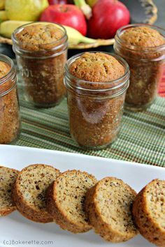 banana bread in jars on a table with apples and bananas