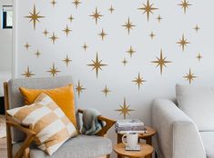 a living room with two couches and a wall that has gold stars on it