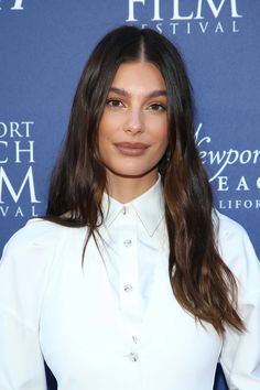 a woman with long hair wearing a white shirt