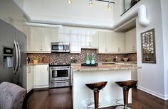 a kitchen with two bar stools next to an oven