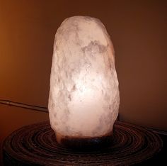 a large white rock sitting on top of a table next to a light bulb in a room