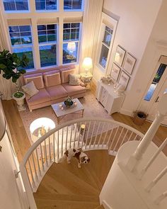 a living room filled with furniture and a spiral stair case next to a large window