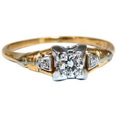 an antique diamond ring with three stones in the center and two diamonds on each side