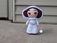 a crocheted doll is standing in front of a door