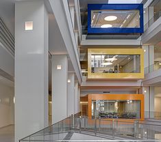 the inside of an office building with glass balconies and stairs leading up to two floors