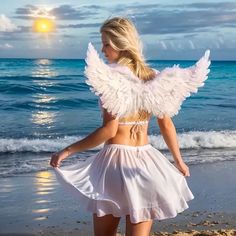 a woman walking on the beach with an angel wings outfit in front of her back