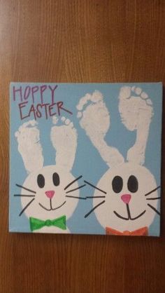 a painting of two rabbits with their hands and feet painted on the canvas, which says happy easter