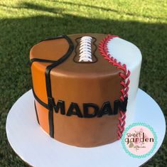 a cake decorated with a baseball and the name madam on it is sitting on a plate