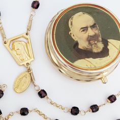 This tiny Padre Pio garnet rosary in a vintage Padre Pio Pill/Rosary Box is a real treasure. The tiny French crucifix and all the garnet stones fit perfectly in the pill box. What a lovely gift to give a devotee of Saint Padre Pio  The rosary measures 18 inches from the bottom of the Cross to the middle of the third decade of Hail Marys. PADRE PIO, also known as Saint Pius of Pietrelcina (25 May 1887 - 23 September 1968), was an Italian Franciscan Capuchin, friar, priest, stigmatist, and mystic, now venerated as a saint in the Catholic Church. Born Francesco Forgione, he was given the name of Pius (Italian: Pio) when he joined the Order of Friars Minor Capuchin. Padre Pio became famous for exhibiting stigmata for most of his life, thereby generating much interest and controversy. He was bo Vintage Gold Rosary As Gift, Antique Gold Rosary As Gift, Garnet Rosary, St Pio Of Pietrelcina, Rosary Boxes, 23 September, Pope John Paul Ii, Pope John, Garnet Stone