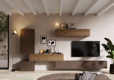 a living room filled with furniture and a flat screen tv on top of a wooden shelf