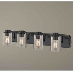 three light bathroom vanity fixture with clear glass shades and black metal finish, in an industrial style