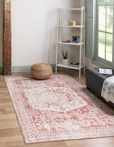 a living room area with a rug, chair and book shelf on the floor in front of a window