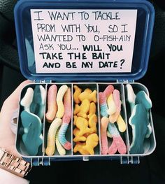 a person holding a container filled with fake fish and gummy bears next to a sign that says, i want to take from with you so i wanted to go