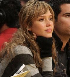 a woman sitting next to a man at a basketball game