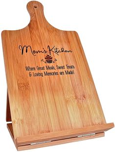 a wooden cutting board with the words mom's kitchen on it