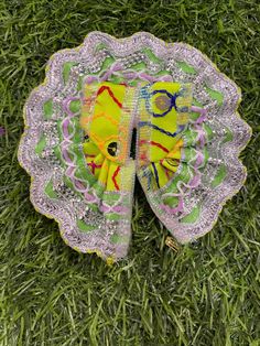 a yellow and green butterfly sitting on top of a lush green field covered in grass