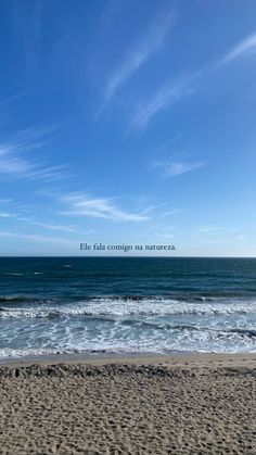 a beach with waves crashing on the sand and blue sky above it, in front of an ocean