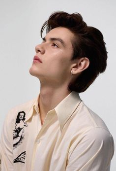 a man with his eyes closed wearing a white shirt and looking up into the sky