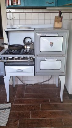 an old fashioned stove with two burners on the front and one oven on the back