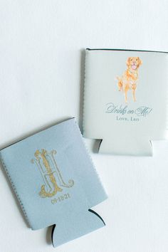 two personalized flasks are shown on a white surface with blue and gold trim