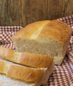 two loaves of bread sitting on top of a checkered cloth