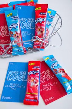 several packets of toothpaste sitting in a wire basket next to each other on a table