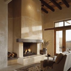 a living room filled with furniture and a fire place in the middle of a room