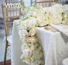 the table is covered with white flowers and gold chairs for an elegant touch to the reception