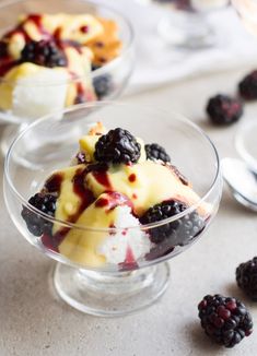 three desserts in small glass dishes with berries on the side