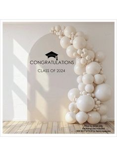 an arch made out of balloons with congratulations written on the wall in front of it